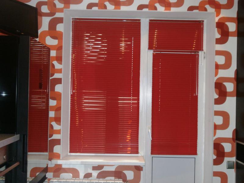 красные алюминиевые жалюзи балконной двери и окна многоэтажки Балгород - закрыто
